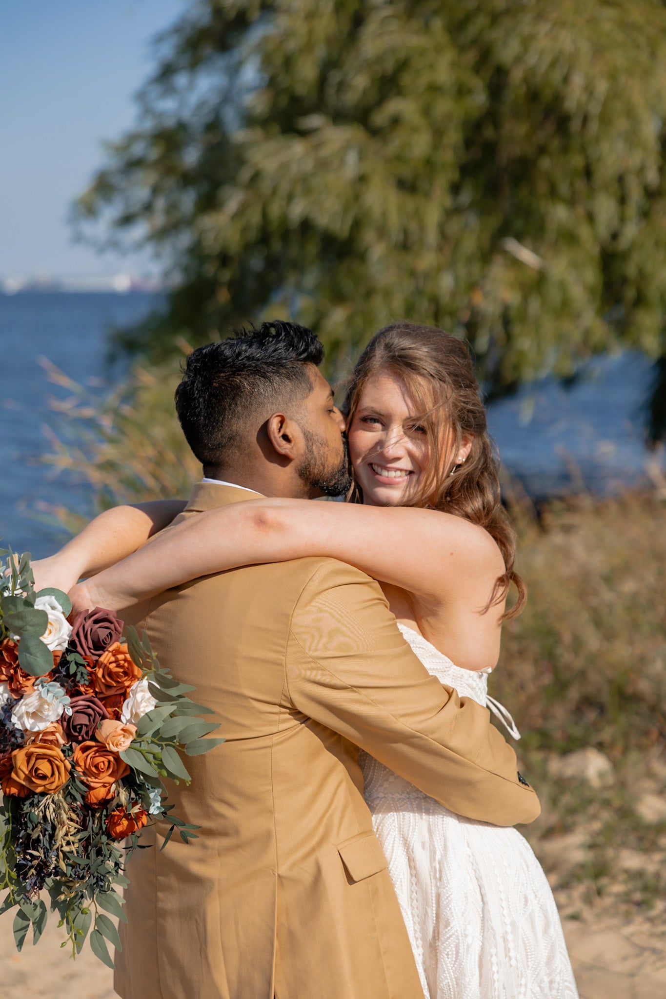 Couple embracing at their waterfront wedding